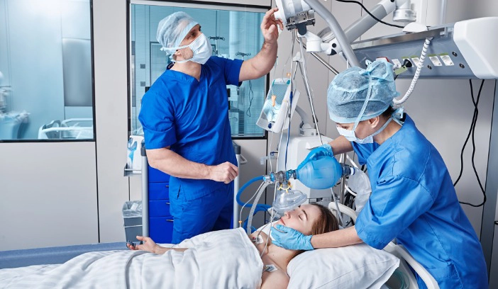 Zwei Atmungstherapeuten behandeln einen Pateinten in einer Weaning-Station.